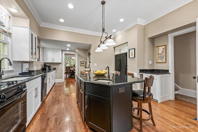558 W Downer Pl, Aurora, IL 60506 - kitchen with black appliances, a breakfast bar area, white cabinetry, glass insert cabinets, and crown molding