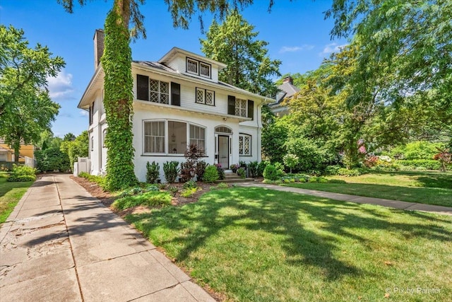 558 W Downer Pl, Aurora, IL 60506 - american foursquare style home with a chimney, a front yard, and stucco siding
