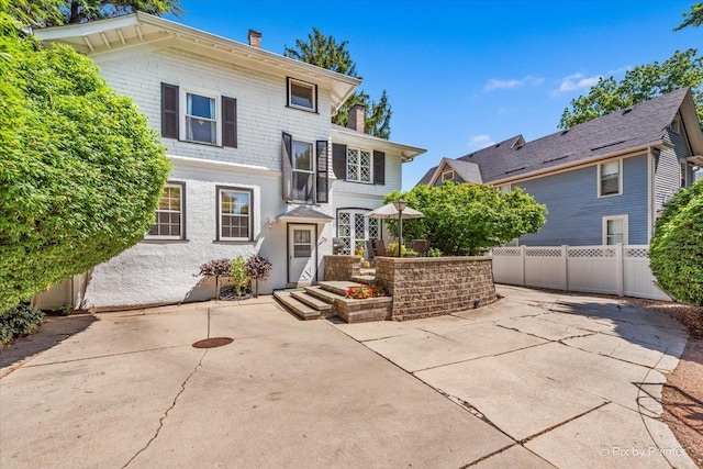 558 W Downer Pl, Aurora, IL 60506 - view of front of house featuring a chimney and a patio area