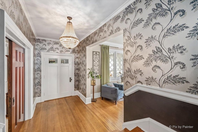 558 W Downer Pl, Aurora, IL 60506 - foyer entrance featuring wallpapered walls, light wood-type flooring, a chandelier, and crown molding