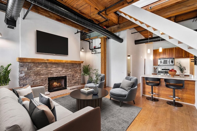 331 S Peoria St Unit Ph6, Chicago, IL 60607 - living room with light wood-type flooring, a fireplace, a towering ceiling, and beam ceiling
