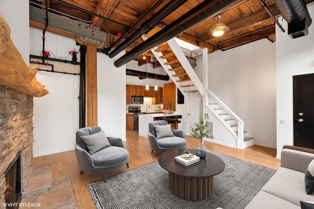 331 S Peoria St Unit Ph6, Chicago, IL 60607 - living area featuring stairway, light wood-style floors, a fireplace, wooden ceiling, and a towering ceiling