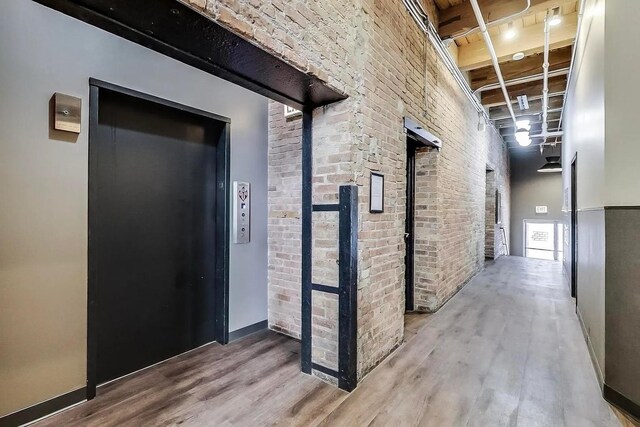 331 S Peoria St Unit Ph6, Chicago, IL 60607 - corridor featuring wood finished floors, brick wall, and elevator