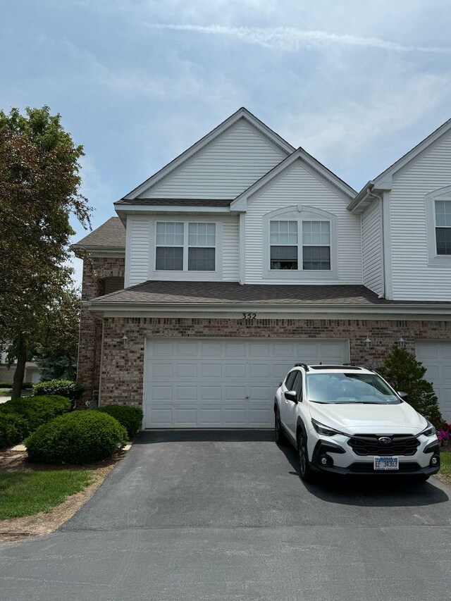 352 Bay Dr, Itasca, IL 60143 - view of property featuring a garage, asphalt driveway, and brick siding