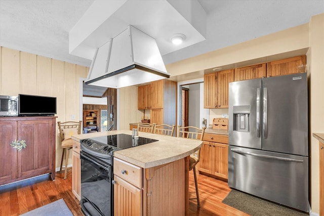 13809 Pine Rd, Dewitt, IL 61735 - kitchen with appliances with stainless steel finishes, light wood-style floors, light countertops, a center island, and a breakfast bar area