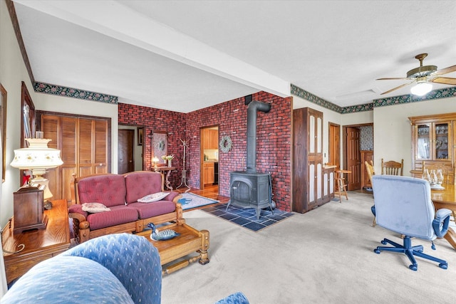 13809 Pine Rd, Dewitt, IL 61735 - living room featuring a wood stove, carpet flooring, brick wall, and a ceiling fan