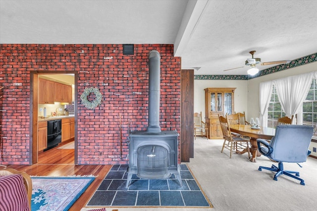 13809 Pine Rd, Dewitt, IL 61735 - living room featuring a wood stove, a textured ceiling, and ceiling fan