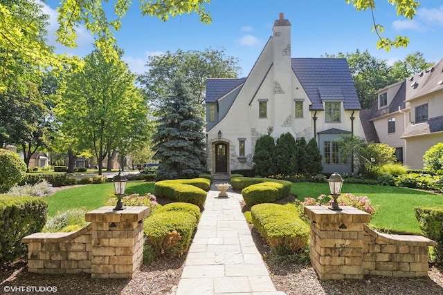 437 N County Line Rd, Hinsdale, IL 60521 - view of front of house featuring a chimney, a front yard, and stucco siding