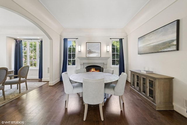 437 N County Line Rd, Hinsdale, IL 60521 - dining area featuring a fireplace, dark wood-style flooring, and arched walkways