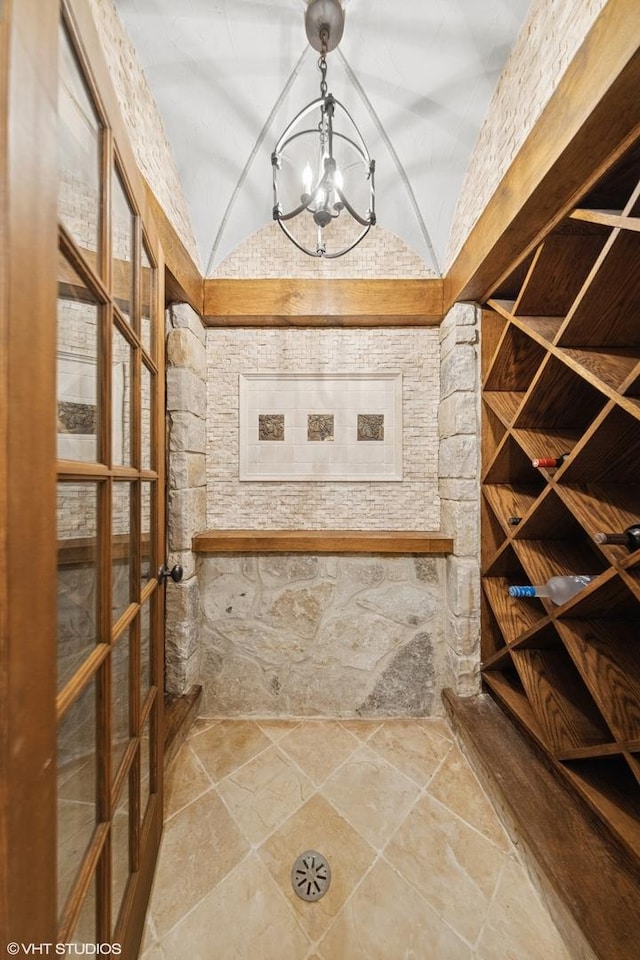 437 N County Line Rd, Hinsdale, IL 60521 - wine room featuring a chandelier, lofted ceiling, and stone finish floors