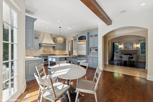 437 N County Line Rd, Hinsdale, IL 60521 - dining room with arched walkways, a chandelier, beamed ceiling, recessed lighting, and a lit fireplace