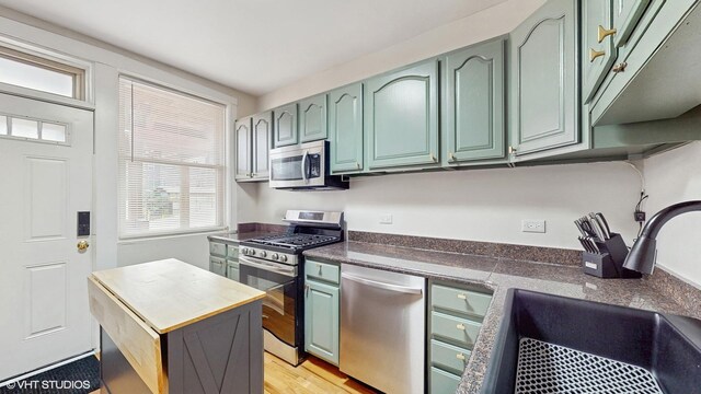3253 W Leland Ave Unit 2, Chicago, IL 60625 - kitchen with stainless steel appliances, green cabinets, and light wood finished floors