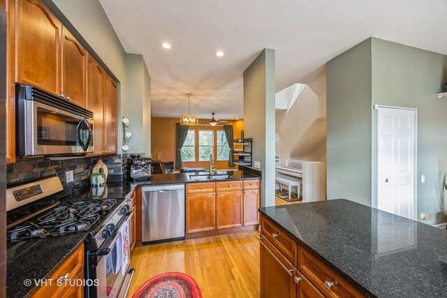 108 Belvidere Ave, Forest Park, IL 60130 - kitchen featuring appliances with stainless steel finishes, light wood-style floors, backsplash, dark stone countertops, and brown cabinets