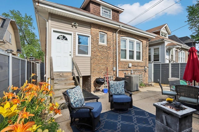 8120 S Luella Ave, Chicago, IL 60617 - back of house featuring entry steps, a fenced backyard, a patio area, brick siding, and a fire pit