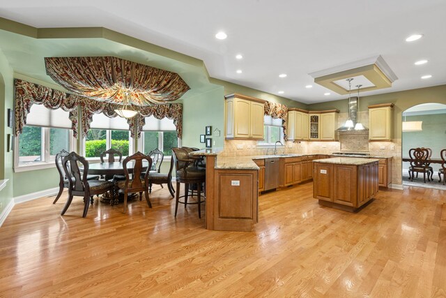 3550 Sorrel Dr, Northbrook, IL 60062 - kitchen with dishwasher, wall chimney exhaust hood, a center island, arched walkways, and backsplash