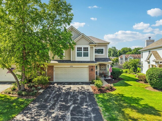 454 Blue Springs Dr, Fox Lake, IL 60020 - view of front of home featuring driveway, a front lawn, brick siding, and a garage
