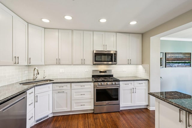 454 Blue Springs Dr, Fox Lake, IL 60020 - kitchen with appliances with stainless steel finishes, dark stone countertops, white cabinetry, decorative backsplash, and ornamental molding