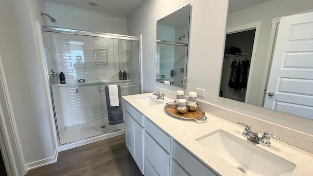 998 Amethyst Ln, Montgomery, IL 60538 - bathroom with a shower stall, double vanity, wood finished floors, and a walk in closet