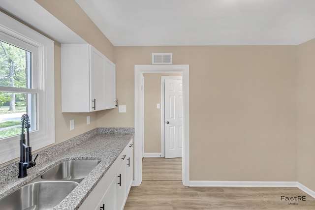 2059 Downey Rd, Homewood, IL 60430 - kitchen featuring white cabinetry, light wood finished floors, and light stone counters