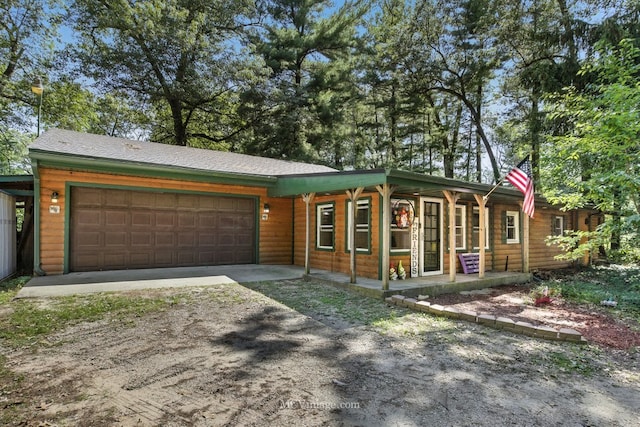 204 Wood St, Wilmington, IL 60481 - view of front of home featuring dirt driveway, an attached garage, a porch, and log veneer siding