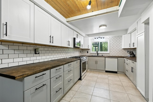 204 Wood St, Wilmington, IL 60481 - kitchen featuring appliances with stainless steel finishes, butcher block countertops, tasteful backsplash, light tile patterned floors, and wood ceiling