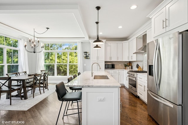 161 N Schubert St, Palatine, IL 60067 - kitchen featuring appliances with stainless steel finishes, wall chimney exhaust hood, a chandelier, white cabinetry, and dark wood-style floors