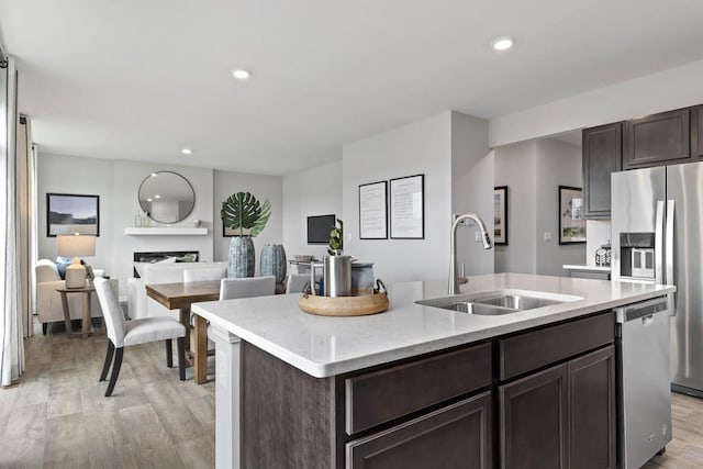 994 Amethyst Ln, Montgomery, IL 60538 - kitchen featuring appliances with stainless steel finishes, dark brown cabinetry, light wood-type flooring, an island with sink, and recessed lighting