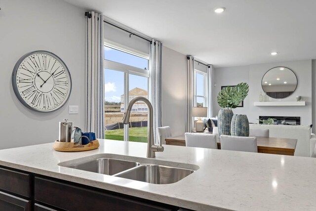 994 Amethyst Ln, Montgomery, IL 60538 - kitchen featuring light stone countertops, a glass covered fireplace, recessed lighting, and open floor plan