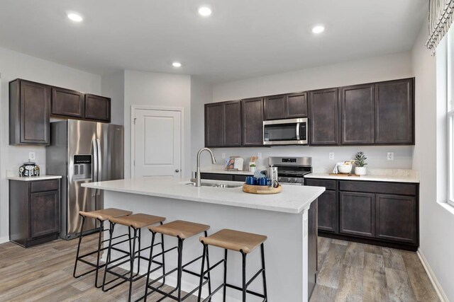 994 Amethyst Ln, Montgomery, IL 60538 - kitchen with stainless steel appliances, light wood-style flooring, dark brown cabinetry, and recessed lighting