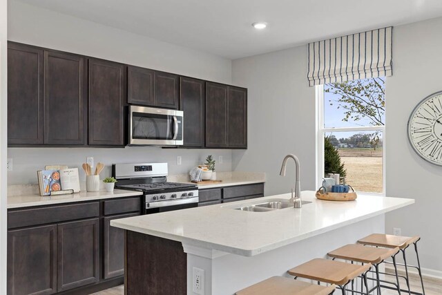 994 Amethyst Ln, Montgomery, IL 60538 - kitchen featuring stainless steel appliances, an island with sink, dark brown cabinets, a breakfast bar area, and recessed lighting