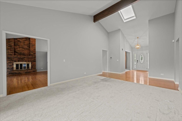 1105 W Bauer Rd, Naperville, IL 60563 - unfurnished living room with carpet floors, high vaulted ceiling, beam ceiling, a brick fireplace, and a skylight