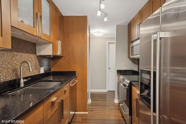 195 N Harbor Dr Unit 709, Chicago, IL 60601 - kitchen featuring stainless steel appliances, brown cabinetry, dark wood finished floors, dark stone counters, and decorative backsplash
