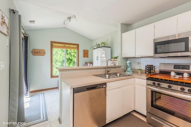 2261 Petworth Ct Unit 201C, Naperville, IL 60565 - kitchen featuring appliances with stainless steel finishes, a peninsula, vaulted ceiling, light countertops, and white cabinets