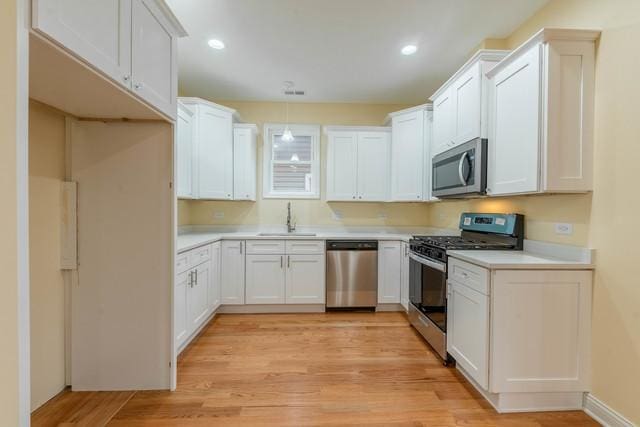 5326 W 31st St, Cicero, IL 60804 - kitchen featuring appliances with stainless steel finishes, light countertops, light wood-style flooring, recessed lighting, and white cabinetry