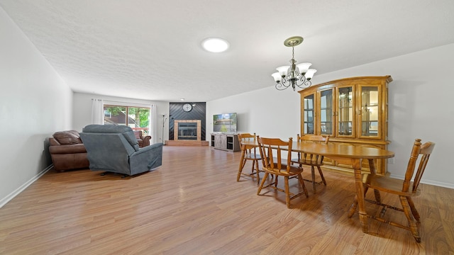 5715 Elaine Dr, Rockford, IL 61108 - dining room with a chandelier, light wood-style floors, and a fireplace