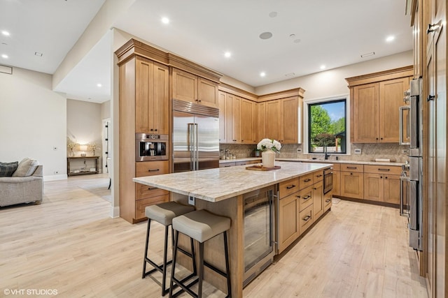 2104 Shermer Rd, Northbrook, IL 60062 - kitchen featuring wine cooler, stainless steel built in fridge, light wood-style flooring, a center island, and light stone countertops