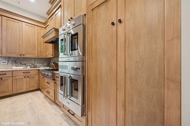 2104 Shermer Rd, Northbrook, IL 60062 - kitchen featuring light wood-style floors, light countertops, backsplash, stainless steel appliances, and custom exhaust hood