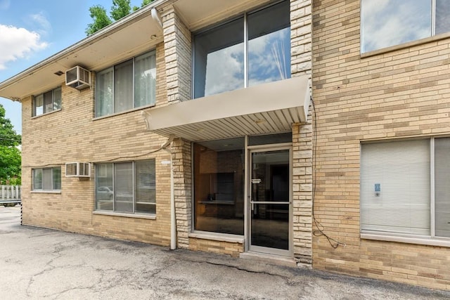 1111 N Harlem Ave Unit 1C, Oak Park, IL 60302 - view of building exterior with a wall mounted AC and a wall unit AC