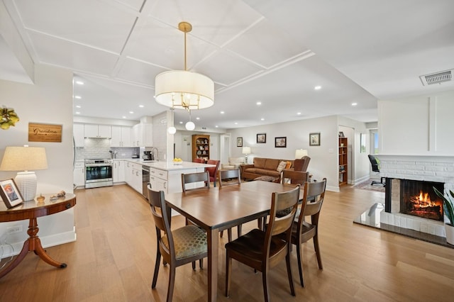3801 Mission Hills Rd Unit 510, Northbrook, IL 60062 - dining space with light wood-style floors, recessed lighting, and a brick fireplace