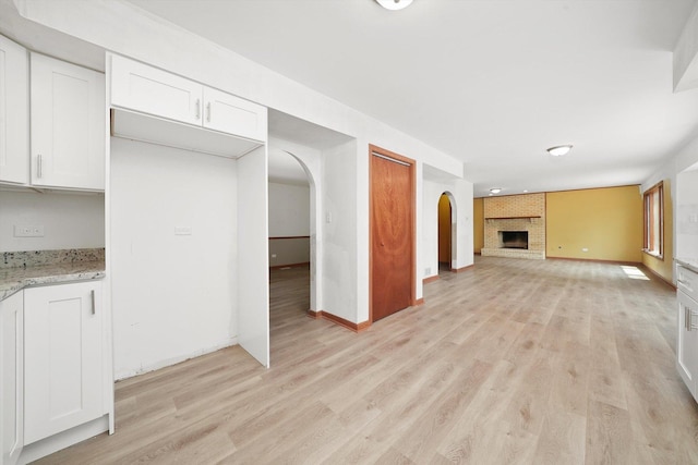 3057 201st Pl, Lynwood, IL 60411 - unfurnished living room featuring light wood-style floors, arched walkways, and a fireplace