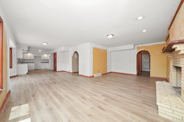 3057 201st Pl, Lynwood, IL 60411 - unfurnished living room featuring arched walkways, a fireplace, light wood finished floors, and recessed lighting
