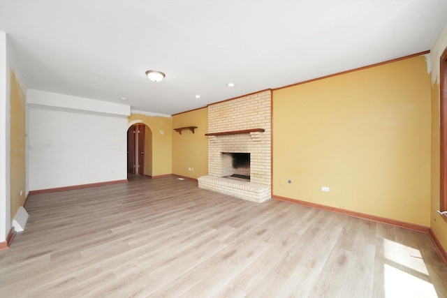 3057 201st Pl, Lynwood, IL 60411 - unfurnished living room featuring light wood finished floors, arched walkways, a fireplace, crown molding, and recessed lighting