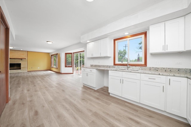 3057 201st Pl, Lynwood, IL 60411 - kitchen featuring white cabinetry, light wood-style floors, light stone counters, open floor plan, and a fireplace