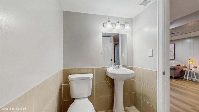 2701 S Hillock Ave, Chicago, IL 60608 - bathroom with tile walls, wood finished floors, and a wainscoted wall