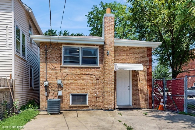 2701 S Hillock Ave, Chicago, IL 60608 - view of front of house with brick siding, a chimney, a gate, and a patio