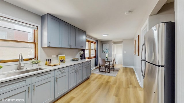 2701 S Hillock Ave, Chicago, IL 60608 - kitchen with freestanding refrigerator, light wood-style flooring, light countertops, and gray cabinets