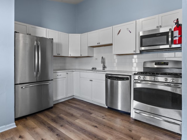 16322 Justine St, Markham, IL 60428 - kitchen featuring stainless steel appliances, backsplash, white cabinetry, light countertops, and dark wood-style floors