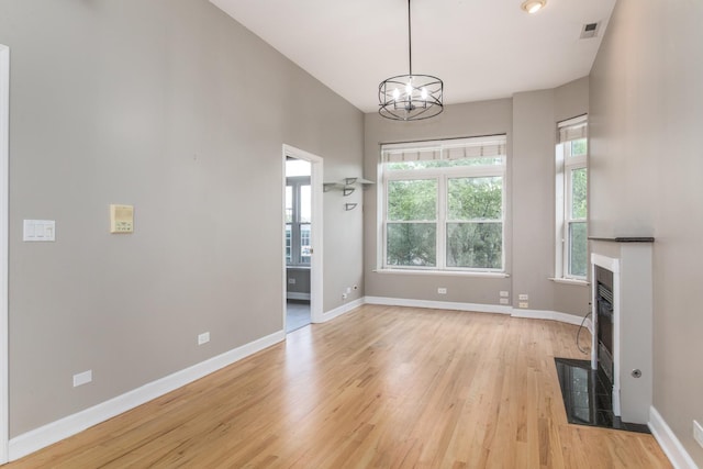 2901 W Washington Blvd Unit 2, Chicago, IL 60612 - unfurnished living room featuring light wood-style floors, a chandelier, and a fireplace with flush hearth