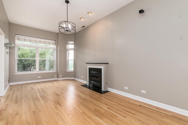 2901 W Washington Blvd Unit 2, Chicago, IL 60612 - unfurnished living room featuring light wood-type flooring, a fireplace with flush hearth, and a chandelier