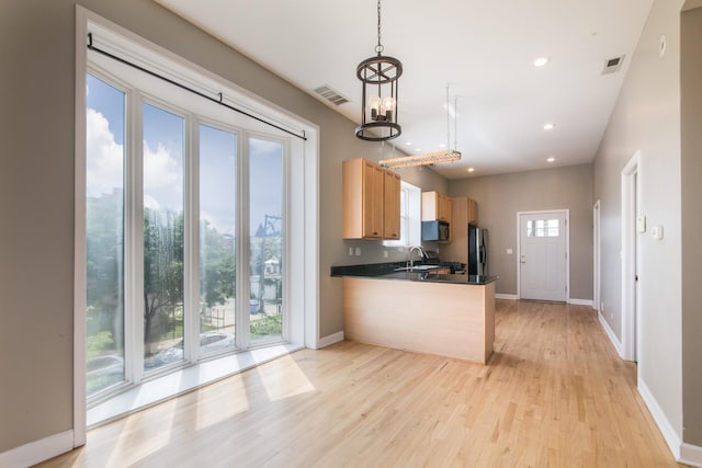 2901 W Washington Blvd Unit 2, Chicago, IL 60612 - kitchen with stainless steel refrigerator with ice dispenser, black microwave, light wood finished floors, dark countertops, and a peninsula